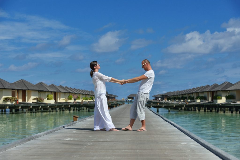 happy-young-couple-have-fun-relax-summer-vacation-background-maldives-travel-location-beautiful-white-sand-beach (1)